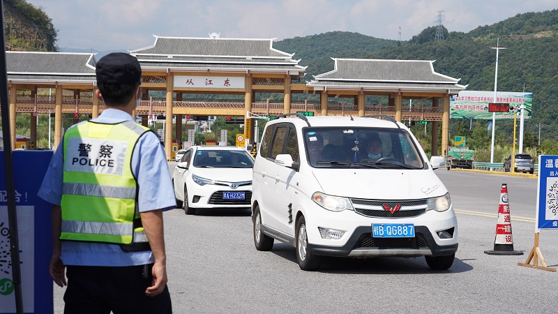 2021年10月1日，在夏蓉高速从江东站，交警队员正在疏导车辆人员下车登记、量体温并扫描健康码。 (2)