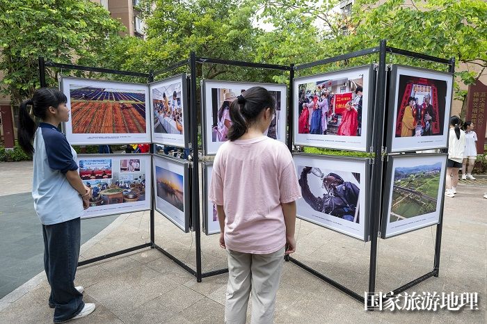 11、2024年7月20日，居民在广西梧州市万秀区蓝天社区蓝天港湾小区观看摄影展。（何华文）